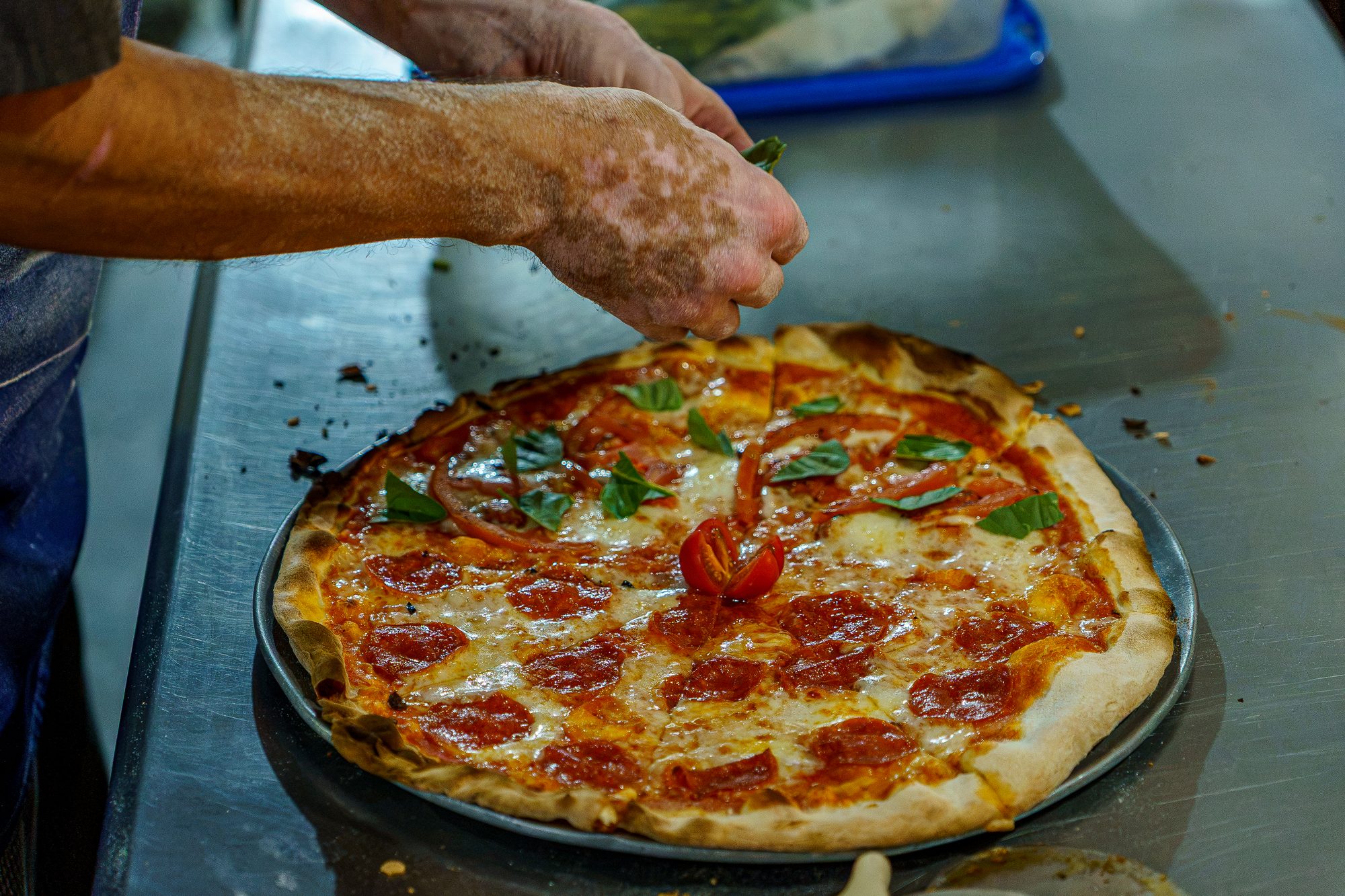 Pizza recién horneada con albahaca en la cocina de Harker