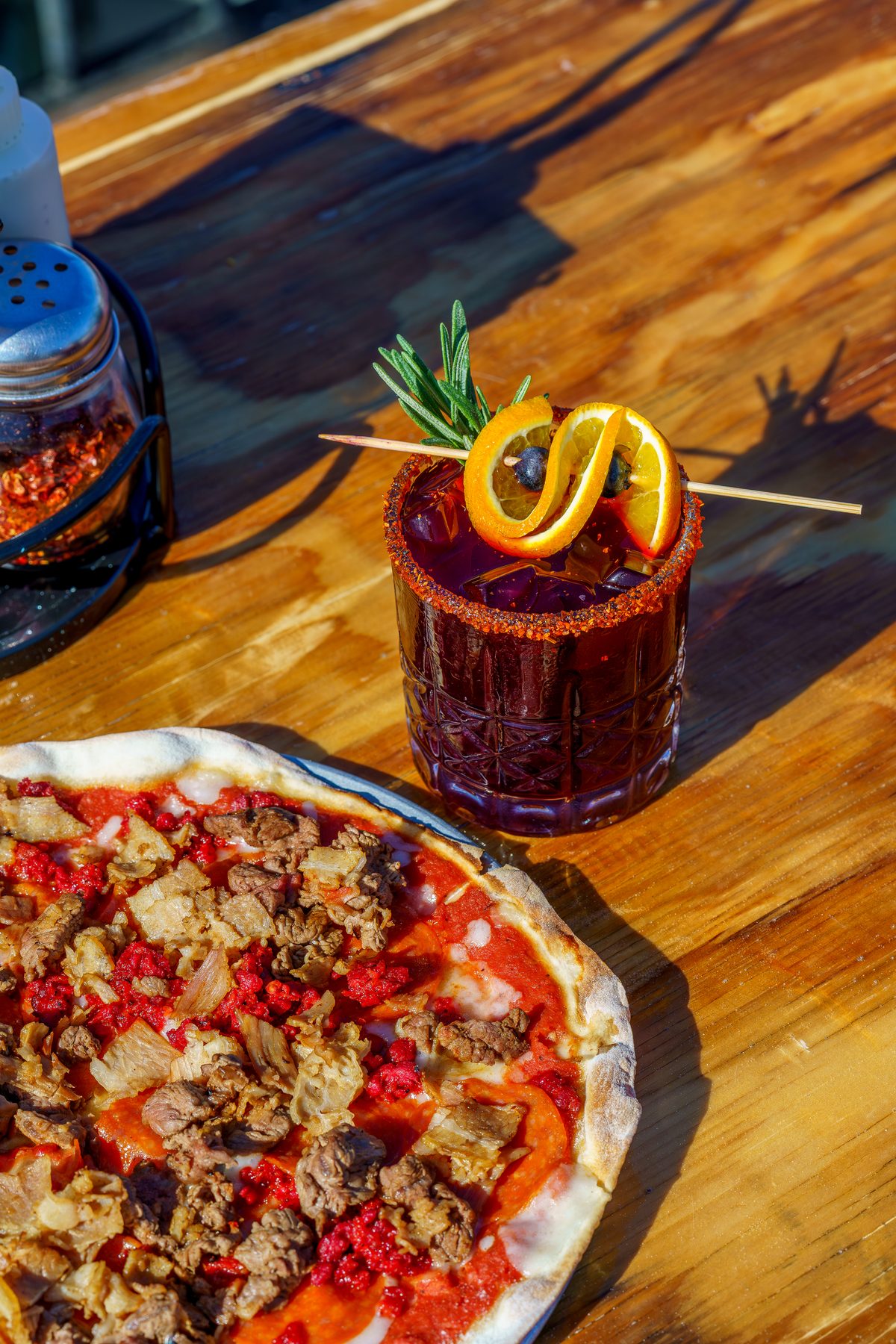 Pizza amantes de la carne con coctel artesanal